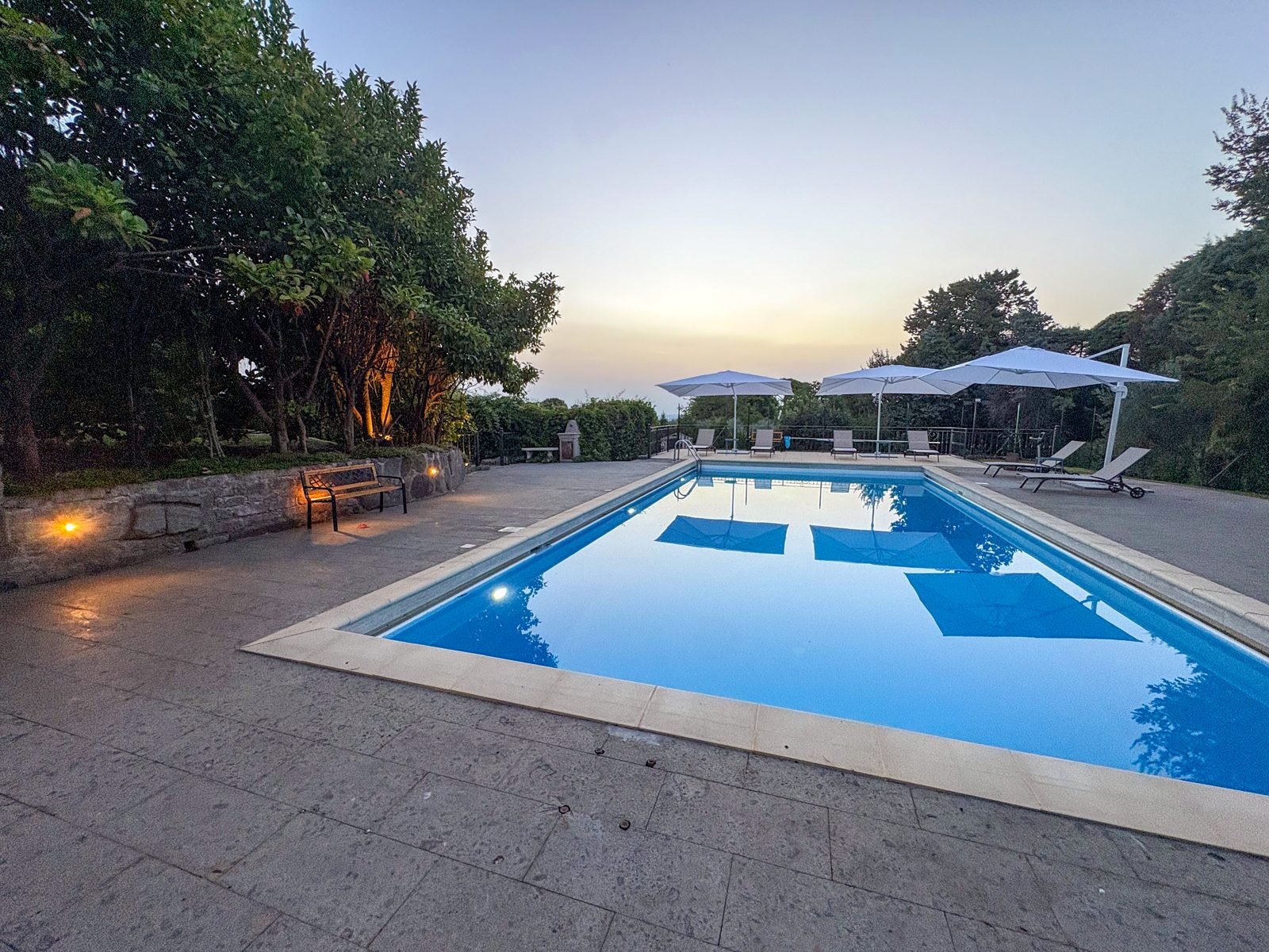 The pool at dusk with the lights coming on