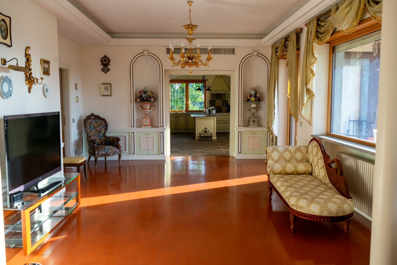 The main salon with chandelier, evening light on the terracotta floor