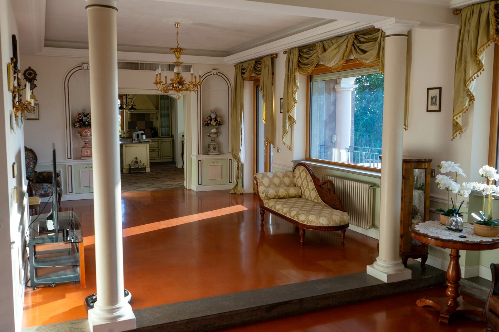 The salon: columns, chaise longue and the window onto the terrace