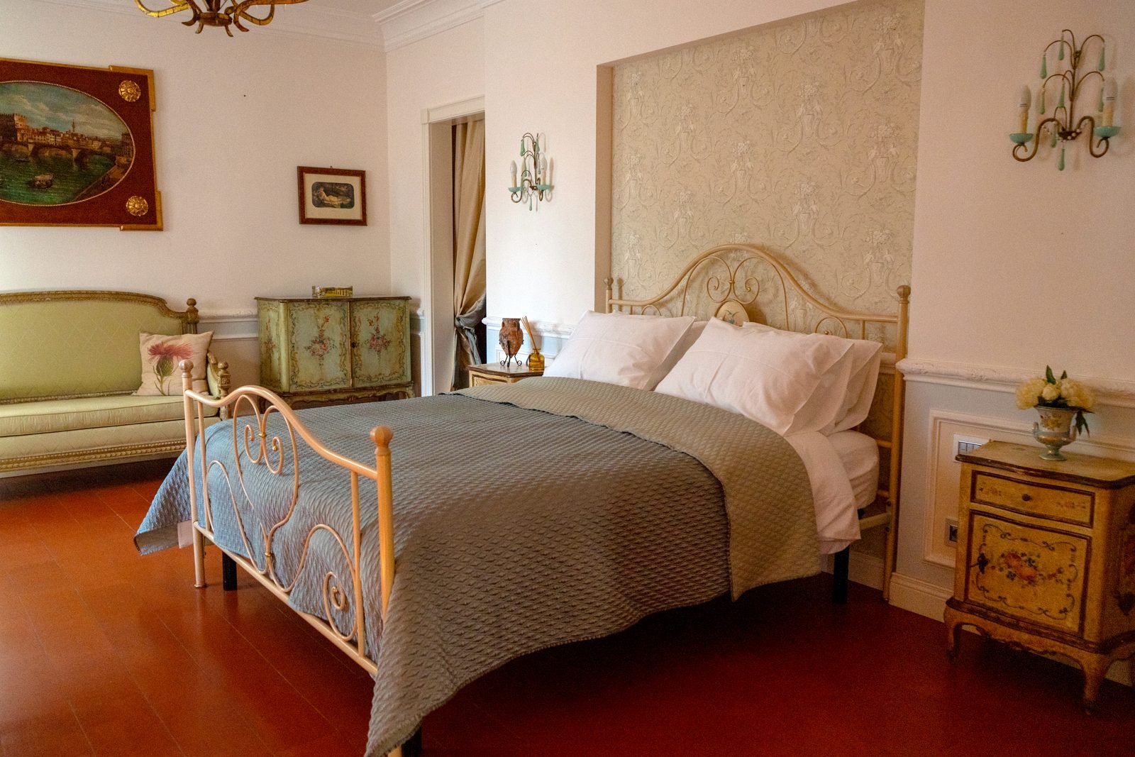 A bedroom with wrought-iron bed and painted furniture